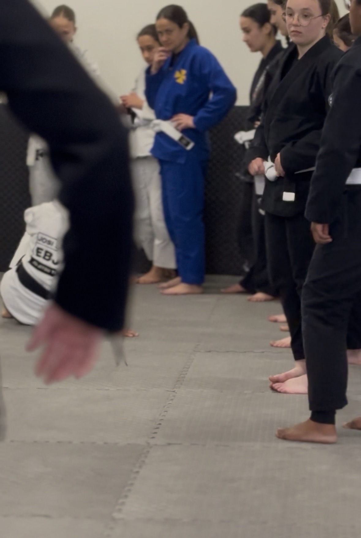 Turma feminina alinhada no início da aula de Jiu-Jitsu